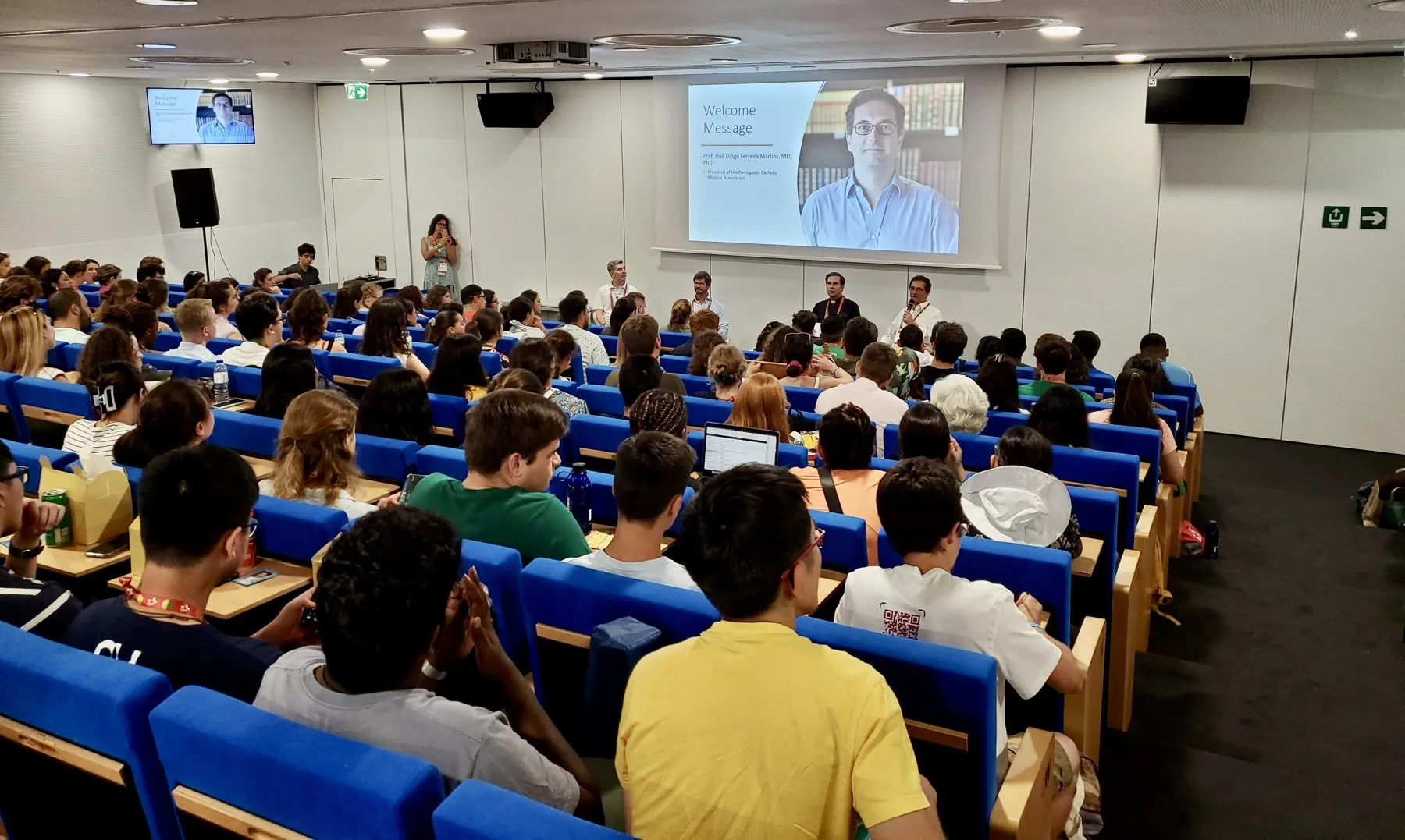 Audience of young doctors listening to a welcome message in a lecture hall